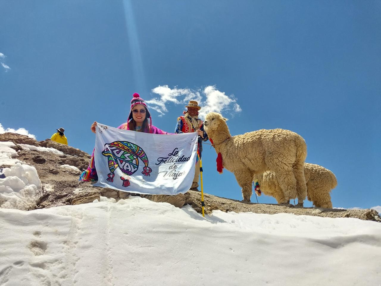 Viajera de Kusiyay con alpacas sobre la nieve