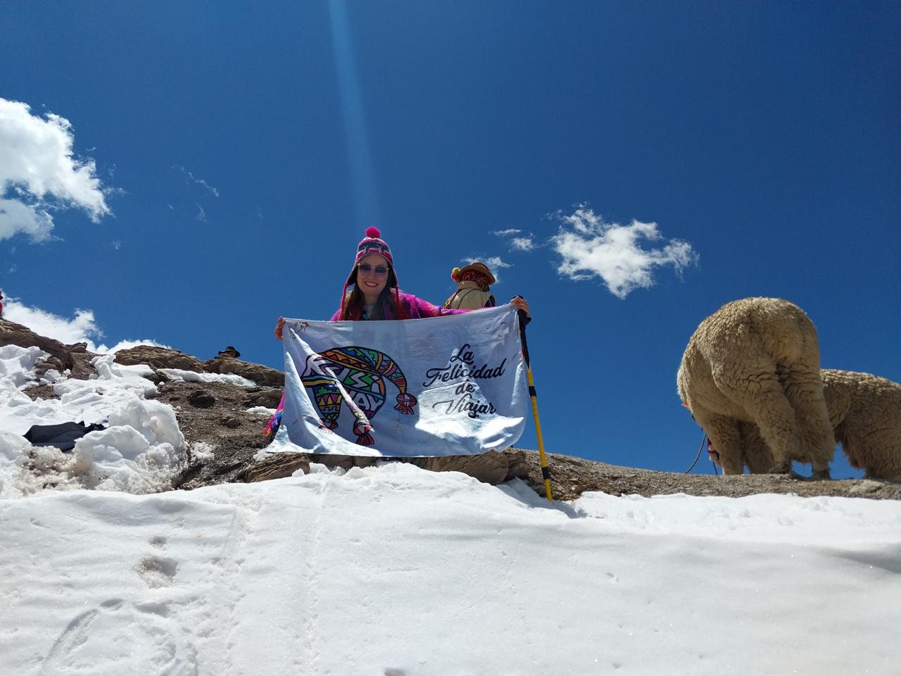 Viajera con la bandera de Kusiyay en la nieve de Ausangate